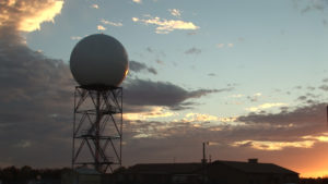 A NOAA Radar Unit stands before a setting sun. Image: NOAA